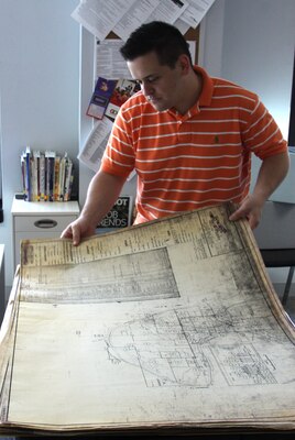 Army veteran Nicholas Genthon examines historical maps of Harry S. Truman Reservoir while working in the Veterans Curation Program's St. Louis lab. The maps are part of a collection of documents given to the Veterans Curation Program by the Corps' Kansas City District for restoration and preservation, and helped inform a research project that combined the historic maps with modern GIS software.