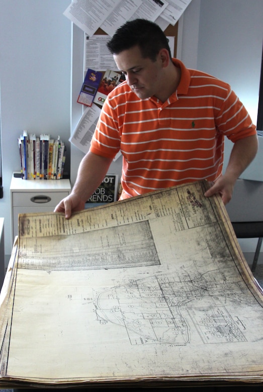Army veteran Nicholas Genthon examines historical maps of Harry S. Truman Reservoir while working in the Veterans Curation Program's St. Louis lab. The maps are part of a collection of documents given to the Veterans Curation Program by the Corps' Kansas City District for restoration and preservation, and helped inform a research project that combined the historic maps with modern GIS software.