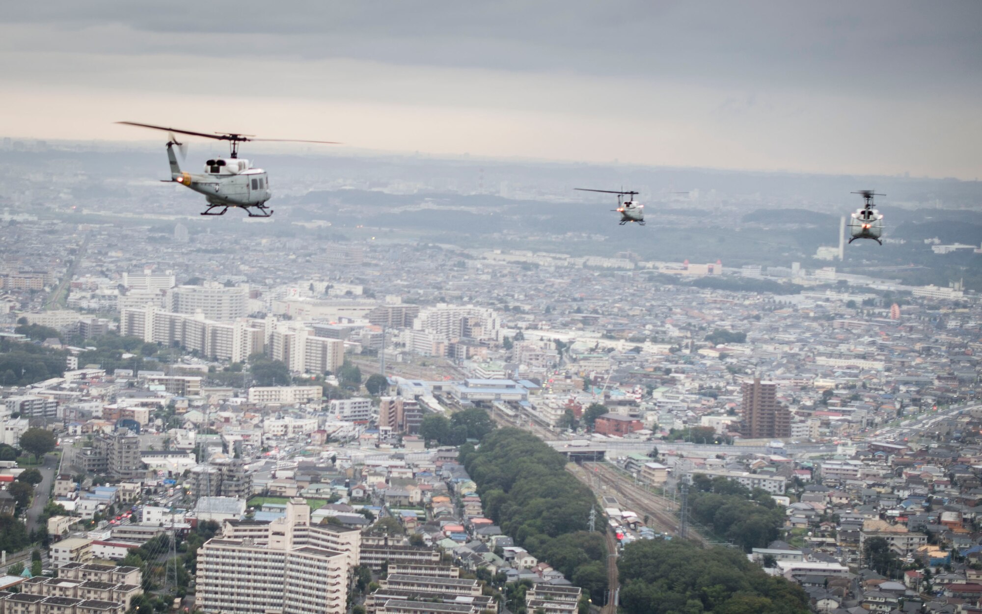 UH-1 Huey helicopters fly over Yokota Air Base, Japan, in formation to test Yokota's professional airlift capabilities during a large formation mission on Oct. 22, 2013. The wing conducts these flight operations to test its capability to prepare and launch multiple aircraft at the same time, highlighting Yokota’s mission as the primary Western Pacific airlift hub for peacetime and contingency operations. (U.S. Air Force photo by Staff Sgt Stacy Moless/released)