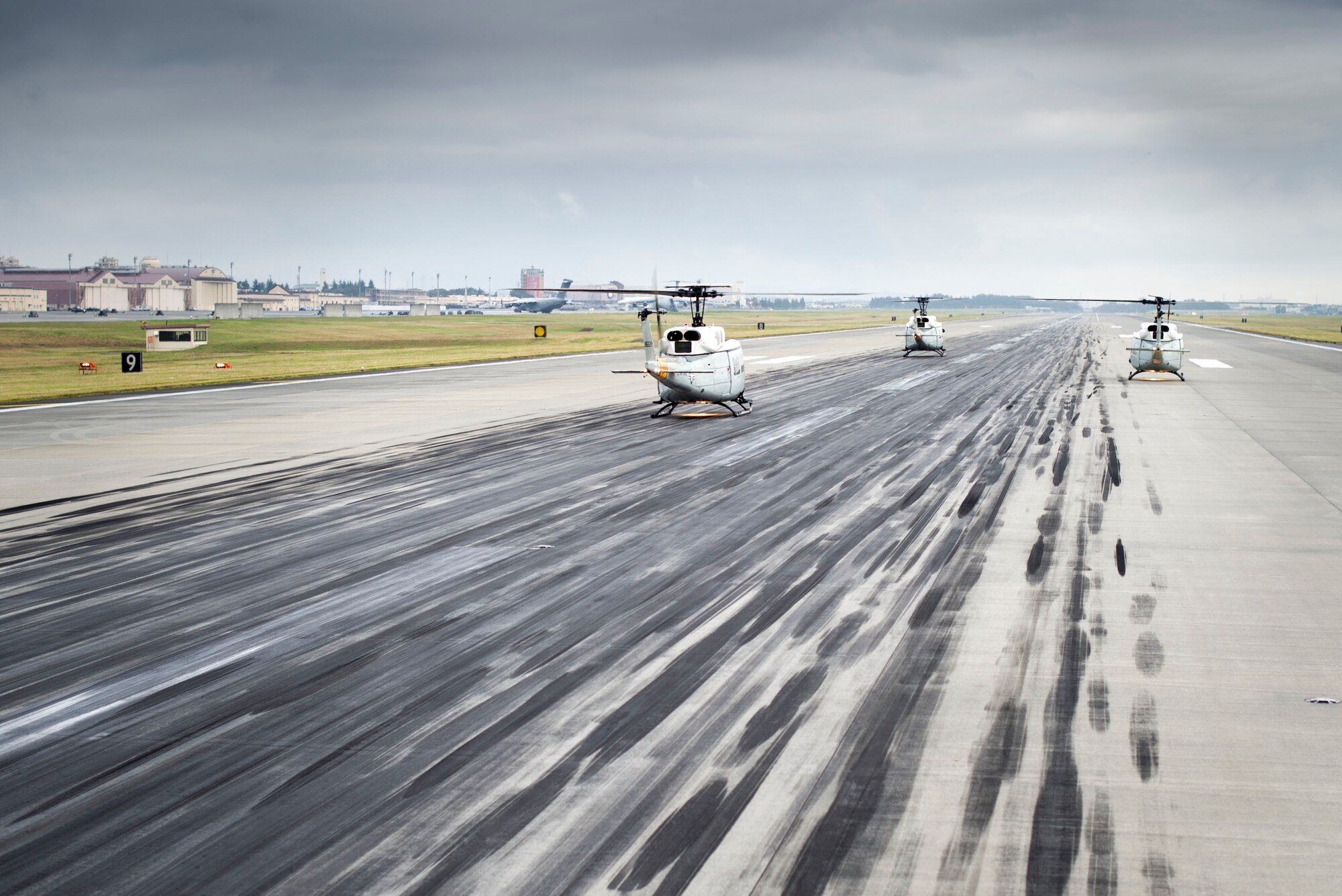 UH-1 Huey helicopters wait on the runway for take off during a large formation mission Oct. 22, 2013, at Yokota Air Base, Japan. The wing conducts these flight operations to test its capability to prepare and launch multiple aircraft at the same time, highlighting Yokota’s mission as the primary Western Pacific airlift hub for peacetime and contingency operations. (U.S. Air Force photo by Staff Sgt Stacy Moless/released)