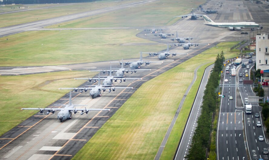 10 C-130 Hercules’ taxi down the runway before takeoff as part of a large formation mission Oct. 22, 2013, at Yokota Air Base, Japan. The wing conducts these flight operations to test its capability to prepare and launch multiple aircraft at the same time, highlighting Yokota’s mission as the primary Western Pacific airlift hub for peacetime and contingency operations. (U.S. Air Force photo by Staff Sgt Stacy Moless/released) 