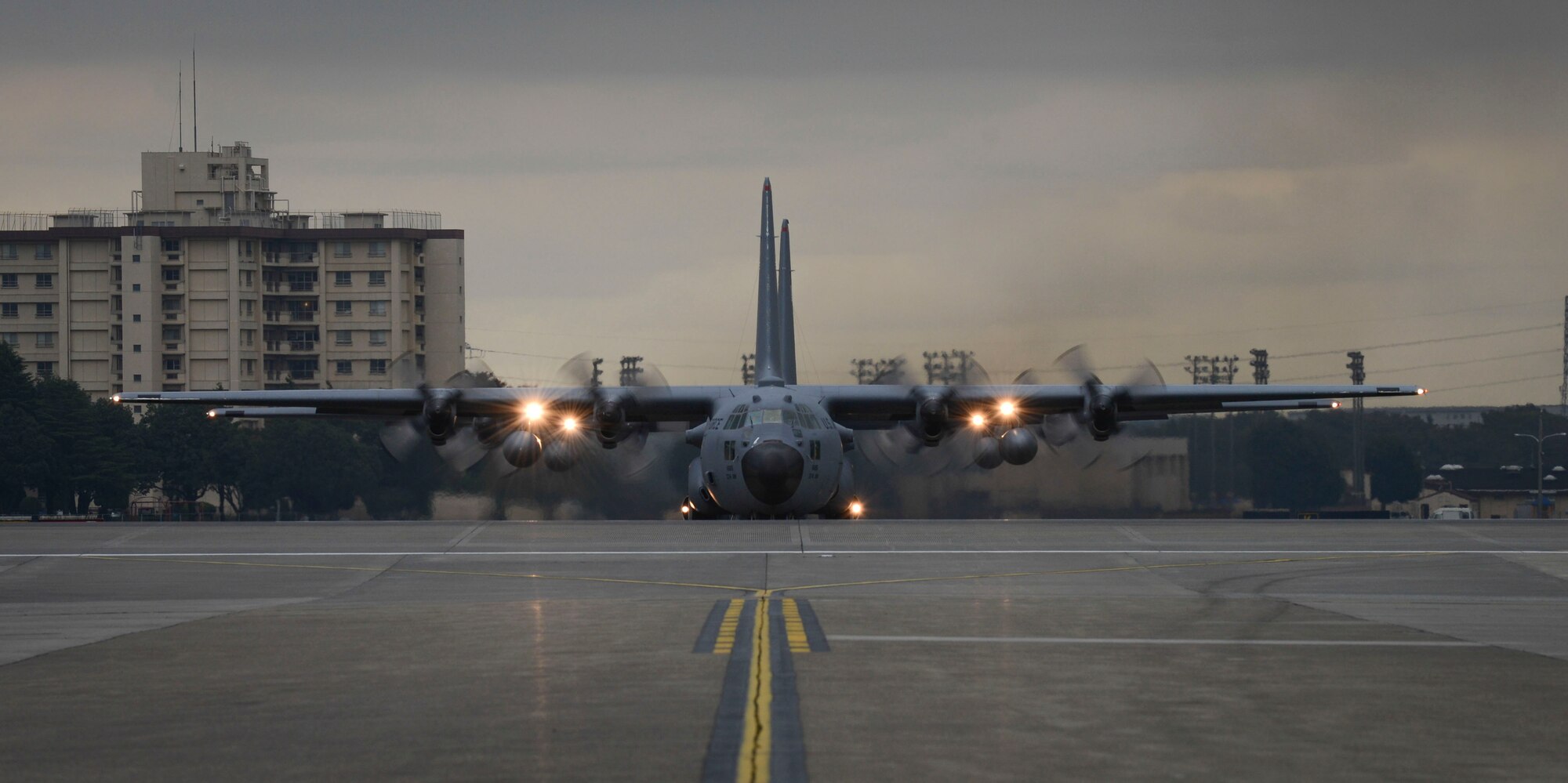 A C-130 Hercules waits on the taxiway at Yokota Air Base, Japan, Oct. 22, 2013.  The wing conducts surge operations to test its capability to prepare and launch multiple aircraft at the same time, highlighting Yokota's mission as the primary Western Pacific airlift hub for peacetime and contingency operations. (U.S. Air Force photo by Airman 1st Class Meagan Schutter/Released)