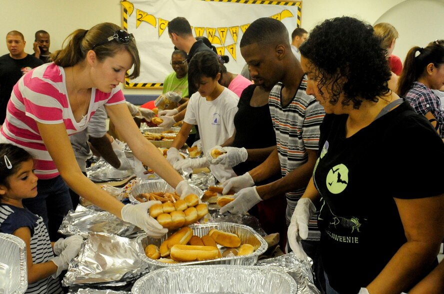 Volunteers wrap hotdogs in aluminum foil in preparation for transport during the Kadena Chapel Outreach Ministry Mission Oct. 19, 2013, on Kadena Air Base, Japan. Volunteers gathered at Chapel 3 to organize food and clothing donated by Kadena members for the homeless and local community. More than 8,000 hotdogs, buns and bottles of water were donated for this community outreach event. (U.S. Air Force photo by Staff Sgt. Darnell T. Cannady)