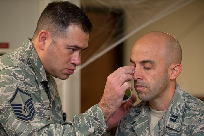 Master Sgt. Jeff Johnson, 99th Inpatient Operations Squadron medical surgery flight chief, applies makeup  to Capt. Steven Fisher, 99th Medical Operations Squadron family advocacy officer, during moulage in preparation for the "Thanks for Asking” Campaign, a Domestic Abuse Awareness Month event Oct. 21, 2013, at Nellis Air Force Base, Nev. The intent of this event is to see how the base populace will react and respond when exercise participants conduct their daily operations with applied simulated bruises. (U.S. Air Force photo by Staff Sgt. Christopher Hubenthal)