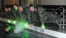 An instructor splashes water at the candidates during phase II of Combat Rescue Officer selection at the base pool at Fairchild Air Force Base, Wash., Oct. 17, 2013. The candidates had to go through eight mile running sessions, water confidence training, leadership challenges and rucksack marches up to six miles. (U.S. Air Force photo by Senior Airman Samantha Krolikowski/ Released) 
