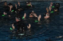 A group of candidates keep their arms above water during an exercise for Combat Rescue Officer selection at the base pool at Fairchild Air Force Base, Wash., Oct. 17, 2013. The candidates were in phase II of the selection which also includes This phase also includes eight mile running sessions, water confidence training, leadership challenges and rucksack marches up to six miles. (U.S. Air Force photo by Senior Airman Samantha Krolikowski/ Released) 