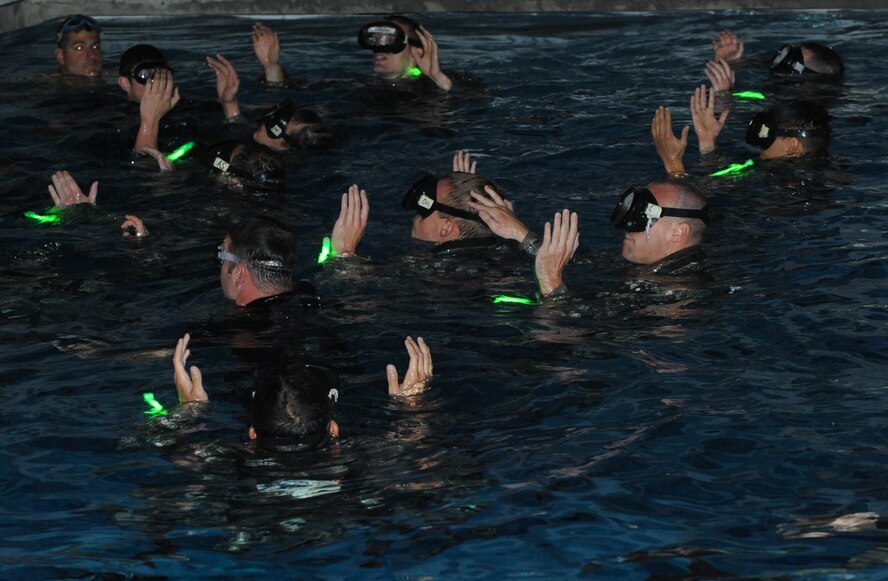 A group of candidates keep their arms above water during an exercise for Combat Rescue Officer selection at the base pool at Fairchild Air Force Base, Wash., Oct. 17, 2013. The candidates were in phase II of the selection which also includes This phase also includes eight mile running sessions, water confidence training, leadership challenges and rucksack marches up to six miles. (U.S. Air Force photo by Senior Airman Samantha Krolikowski/ Released) 