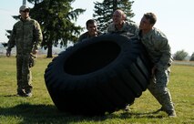Combat Rescue Officer candidates flip a tire during phase two of CRO selection at Fairchild Air Force Base, Wash., Oct. 15, 2013. This phase also includes eight mile running sessions, water confidence training, leadership challenges and rucksack marches up to six miles. (U.S. Air Force photo by Senior Airman Samantha Krolikowski/ Released)