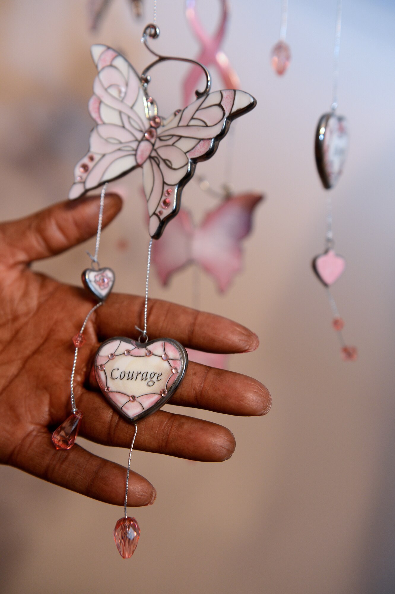 Retired Senior Master Sgt.  Ronshella White looks at the breast cancer awareness wind chime she was given as a gift during her battles with cancer  Oct. 15, 2013, Sumter, S.C.. She focuses on the word courage because it plays a large role with her and her family facing and dealing with her diagnosis of breast cancer. (U.S. Air Force photo by Airman 1st Class Daniel Blackwell/Released)