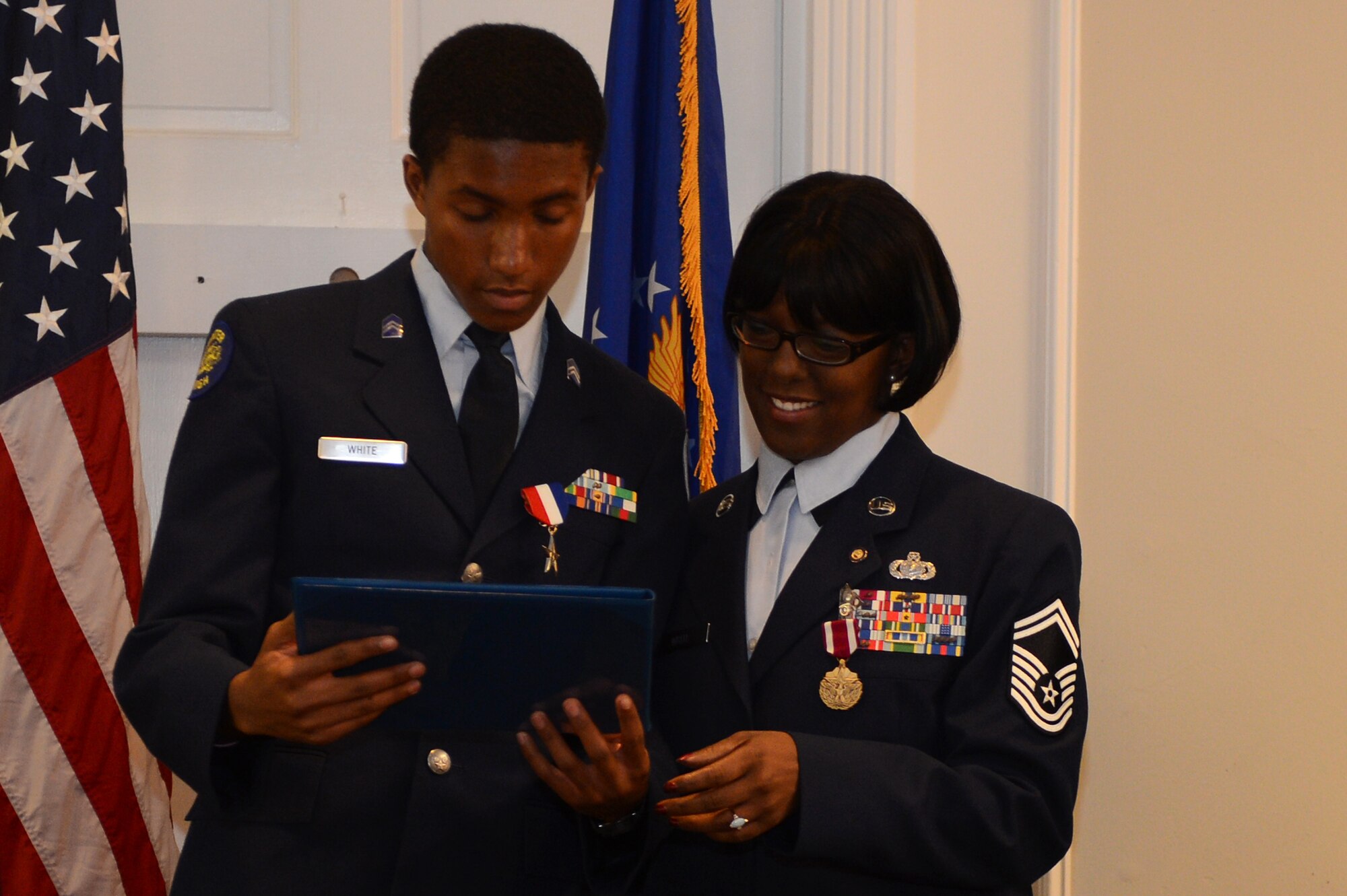 JT White and his mother, retired Senior Master Sgt. Ronshella White, look over the certificate presented to JT during his mother’s retirement ceremony Aug. 22, 2013, at Shaw Air Force Base, S.C. JT was presented the certificate, as well as a commemorative medal, for his role in supporting his mother through her military career and battle with cancer. (U.S. Air Force photo by Airman 1st Class Daniel Blackwell/Released)