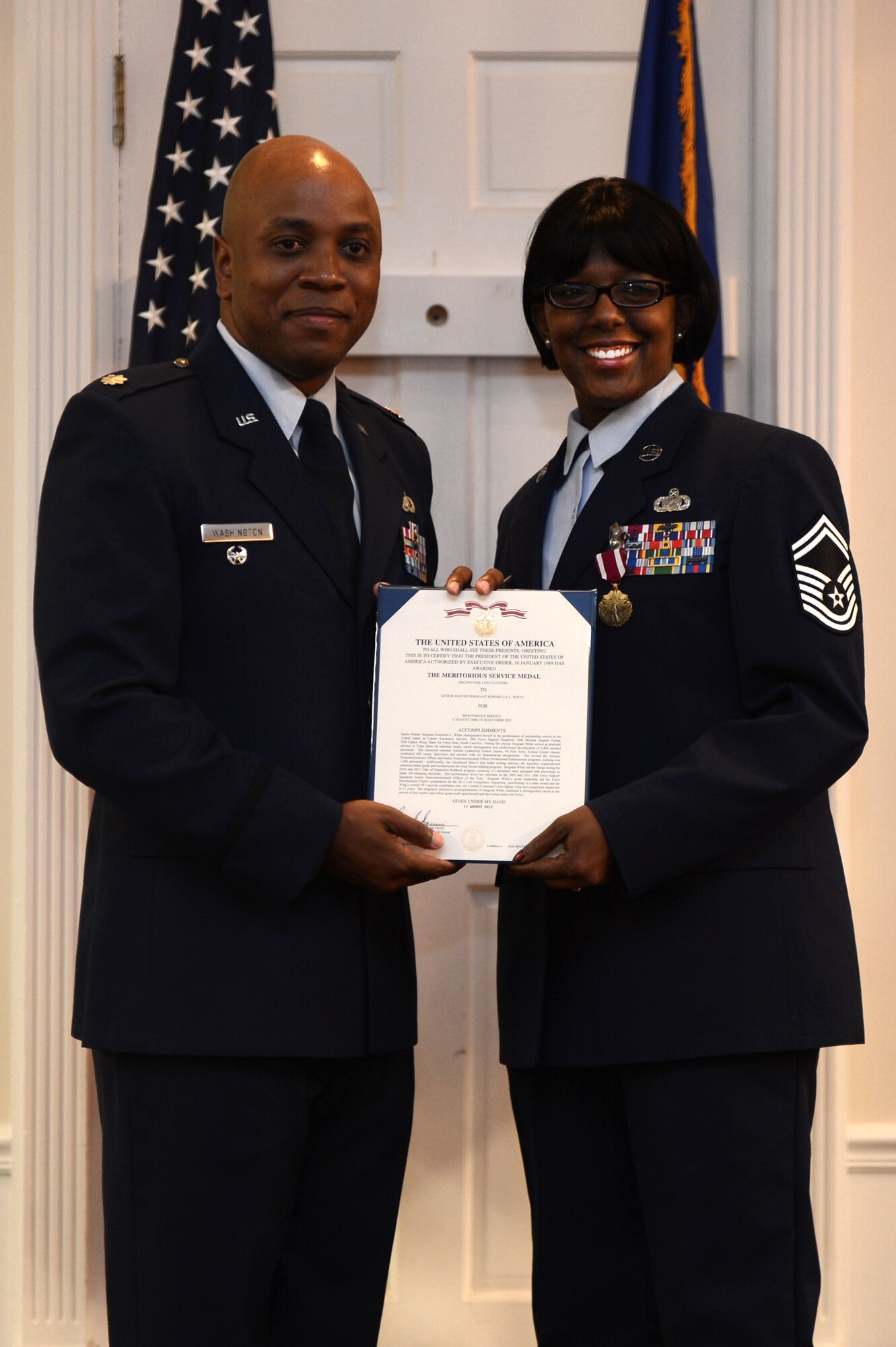 Lt. Col. Dalian Washington (left), former 20th Force Support Squadron commander, presents Senior Master Sgt. Ronshella White with the Meritorious Service Medal during her retirement ceremony Aug. 22, 2013, at Shaw Air Force Base, S.C. The medal was presented to White for her faithful service to her country and the Air Force during her 27-year career. (U.S. Air Force photo by Airman 1st Class Daniel Blackwell/Released)