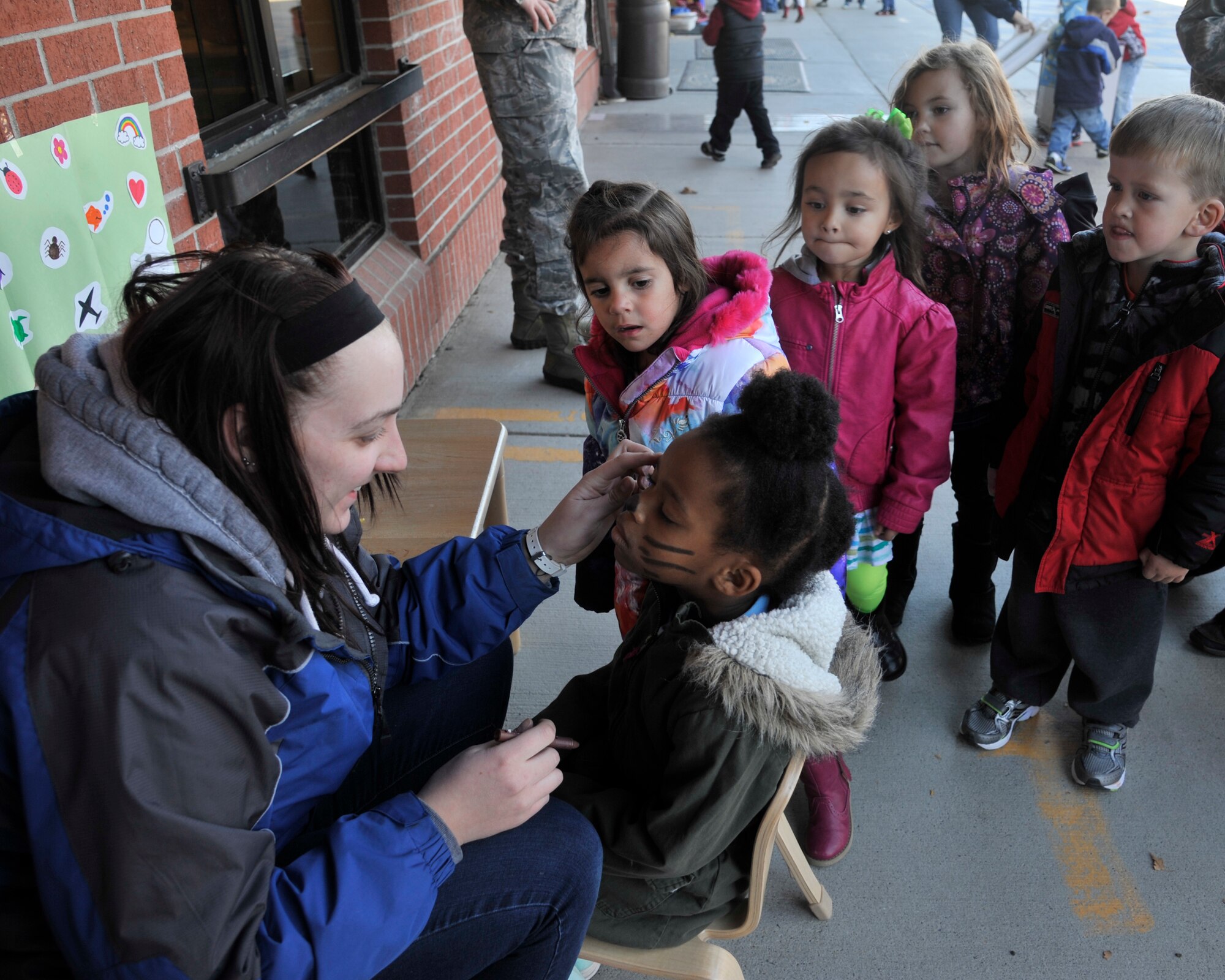 Samantha Brooks, Child Development Center teacher, paints children's faces at the annual Fall Festival at the Child Development Center at Fairchild Air Force Base, Wash., Oct. 18, 2013. Parents were invited to join their children for activites to kick off the fall season. (U.S. Air Force photo by Senior Airman Mary O'Dell/Released))