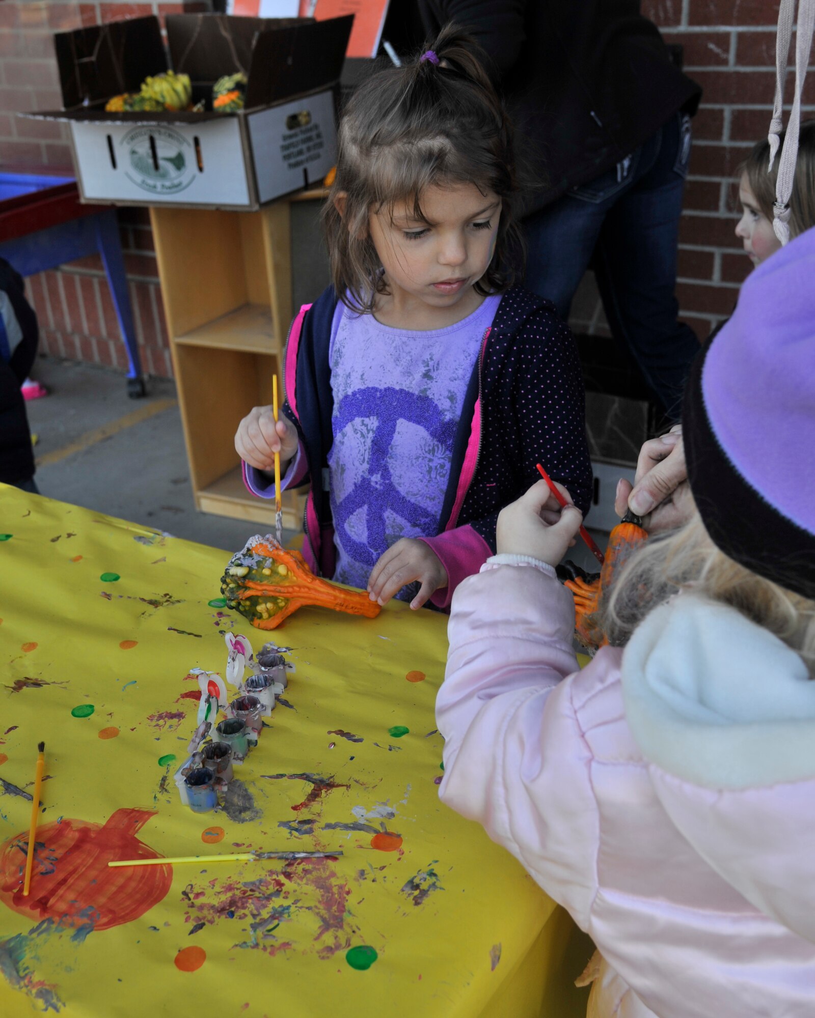 Children paint squash and pumpkins at the annual Fall Festival at the Child Development Center on Fairchild Air Force Base, Wash., Oct. 18, 2013. Every year, the CDC hosts the festival to kick off the fall season with activites for kids and their parents. (U.S. Air Force photo by Senior Airman Mary O'Dell/Released)