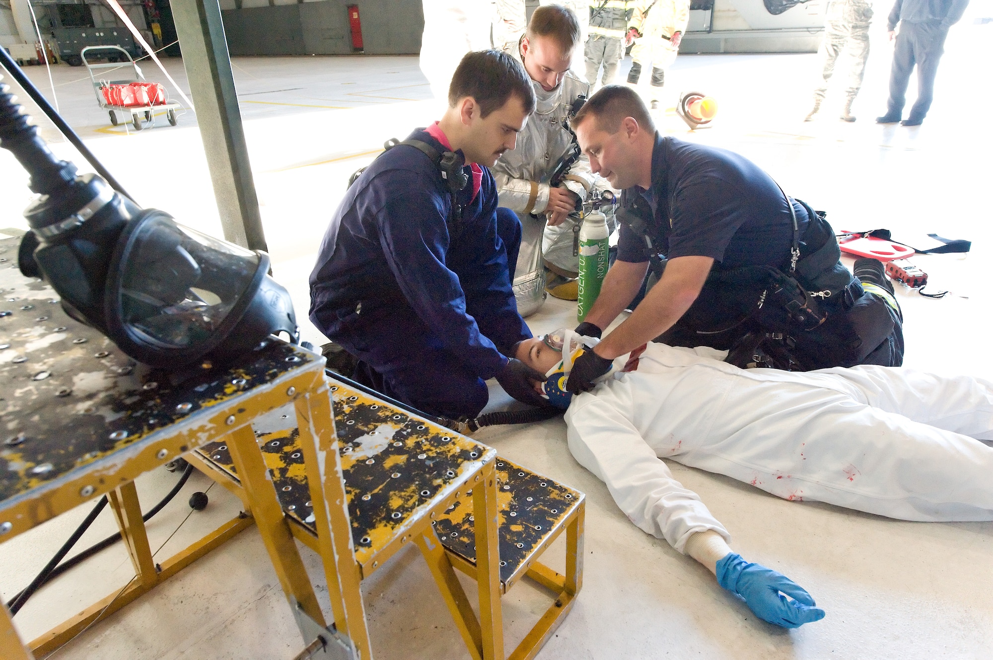 First responders from the 436th Civil Engineer Squadron Fire Department, provide care to simulated victim Airman 1st Class Joshua Lamontagne, 436th Maintenance Squadron, Oct. 18, 2013, at Dover Air Force Base, Del. Lamontagne, an aircraft fuels system maintainer, played the part as a victim with a head injury during an annual confined-space rescue exercise.  (U.S. Air Force photo/Roland Balik)
