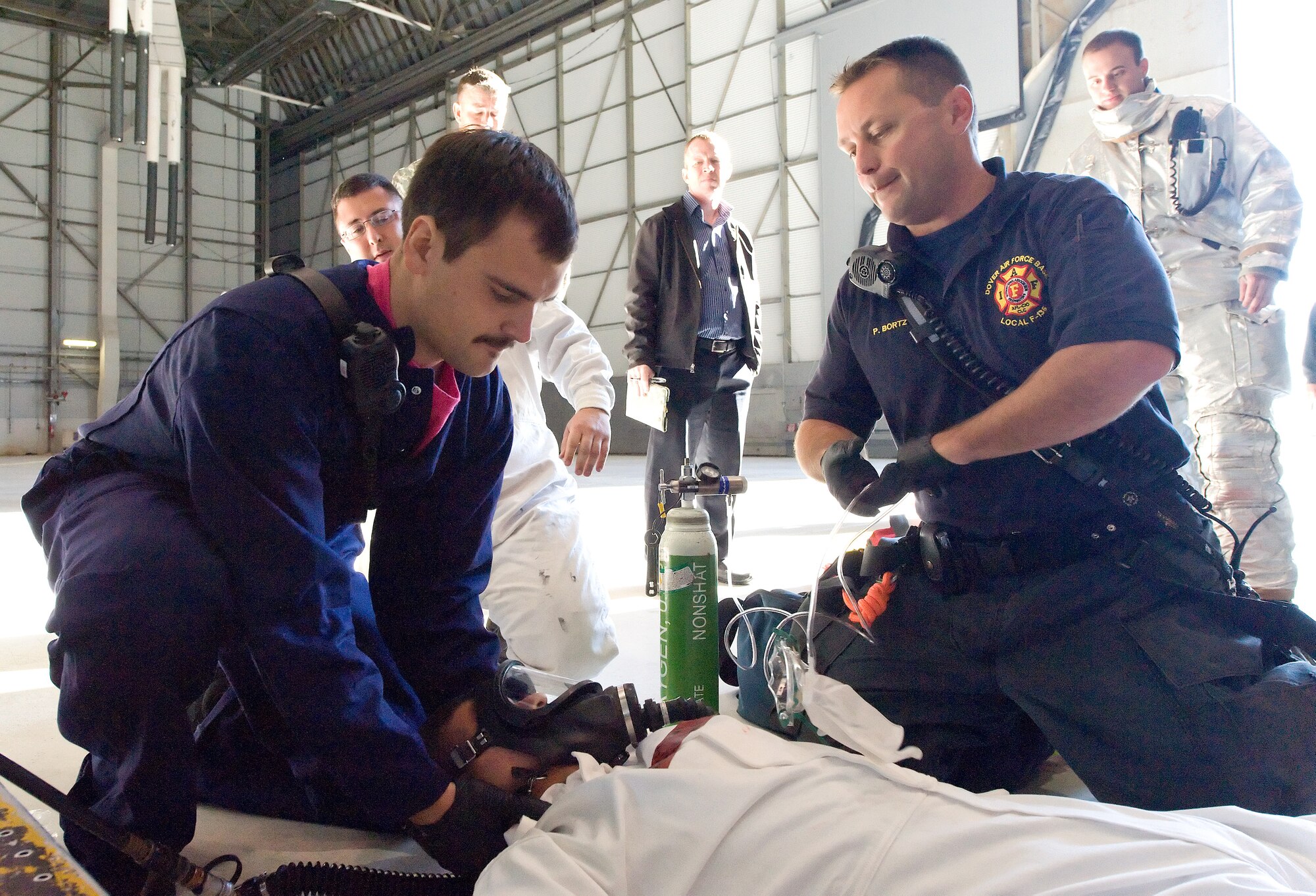Michael Palatucci, left, and Peter Bortz, right, both from the 436th Civil Engineer Squadron Fire Department, provide care to simulated victim Airman 1st Class Joshua Lamontagne, 436th Maintenance Squadron, Oct. 18, 2013, at Dover Air Force Base, Del. Dover AFB first responders and 436th MXS Aircraft Fuel Systems Repair  personnel were evaluated during their annual confined-space rescue exercise. (U.S. Air Force photo/Roland Balik)

