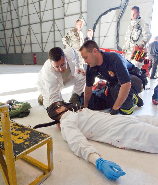 Senior Airman Jason Morton, left, 436th Maintenance Squadron, and Peter Bortz, right, 436th Civil Engineer Squadron Fire Department, provide care to simulated victim Airman 1st Class Joshua Lamontagne, 436th MXS, Oct. 18, 2013, at Dover Air Force Base, Del. Aircraft fuel systems repair facility personnel and Dover AFB first responders were evaluated during their annual confined-space rescue exercise. (U.S. Air Force photo/Roland Balik)