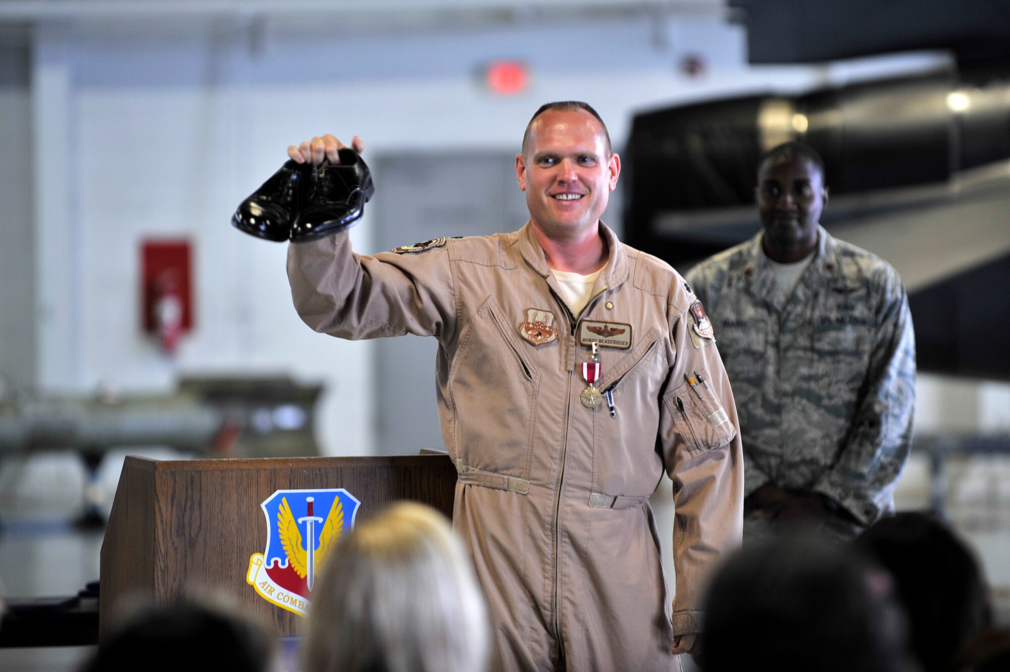 U.S. Air Force Lt. Col. Neaderhiser, 609th Air and Space Operations Center Chief of Contingency Operations, holds up his low-quarters during his retirement ceremony Shaw Air Force Base S.C., Oct 18, 2013.  Neaderhiser told the crowd that he had never purchased another pair of low-quarters since he had been issued them at the beginning of his 21-year career in the Air Force.  (U.S. Air Force photo by Airman 1st Class Jensen Stidham/Released)