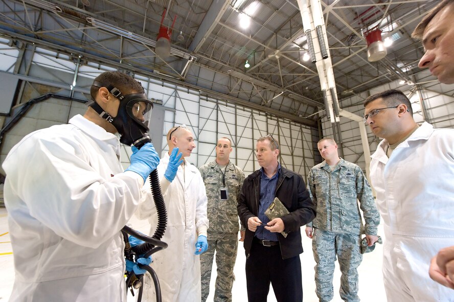 Tim Hahn, from the 436th Airlift Wing Ground Safety office, listens to Senior Airman Brandon Reeves, 436th Maintenance Squadron, prior to a confined-space rescue exercise Oct. 18, 2013, at Dover Air Force Base, Del. The exercise scenario was designed to test emergency actions taken by aircraft fuel systems repair personnel and response time by the 436th Civil Engineer Squadron Fire Department. (U.S. Air Force photo/Roland Balik)