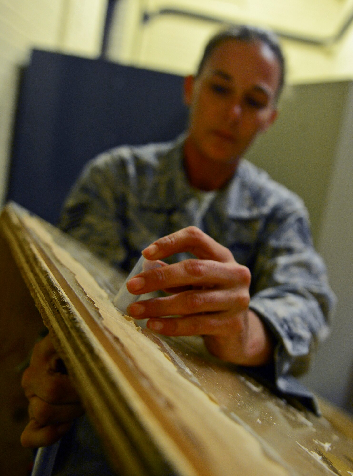 Staff Sgt. Evelyn Clemons, 2nd Civil Engineer Squadron water and fuel systems maintenance craftsman, guides a hose through a hole at the old Security Forces Confinement Facility on Barksdale Air Force Base, La., Oct. 22, 2013. Airmen from the 2nd CES used their skills and knowledge to build props and transform the facility into the annual CE Haunted House. (U.S. Air Force photo Senior Airman Micaiah Anthony)
