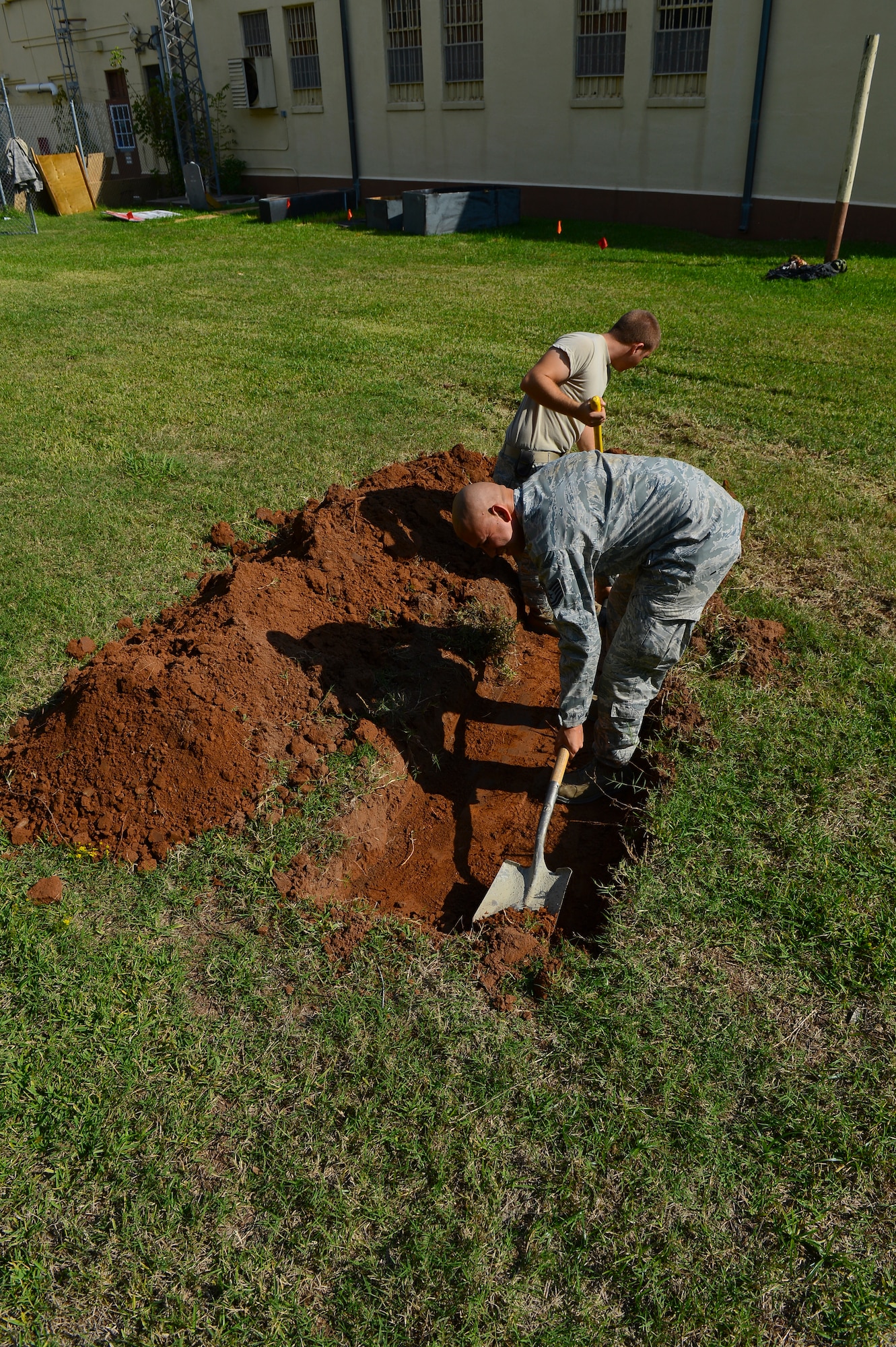 Tech Sgt. David Torres and Senior Airman Anthony Ohl, 2nd Civil Engineer Squadron heavy repairs craftsman and apprentice, dig a hole at the old Security Forces Confinement Facility on Barksdale Air Force Base, La., Oct. 22, 2013. Airmen from the 2nd CES used their skills and knowledge to build props and transform the facility into the annual CE Haunted House. (U.S. Air Force photo Senior Airman Micaiah Anthony)
