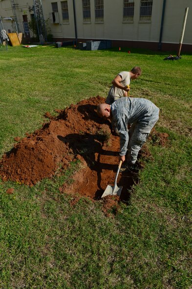 Tech Sgt. David Torres and Senior Airman Anthony Ohl, 2nd Civil Engineer Squadron heavy repairs craftsman and apprentice, dig a hole at the old Security Forces Confinement Facility on Barksdale Air Force Base, La., Oct. 22, 2013. Airmen from the 2nd CES used their skills and knowledge to build props and transform the facility into the annual CE Haunted House. (U.S. Air Force photo Senior Airman Micaiah Anthony)