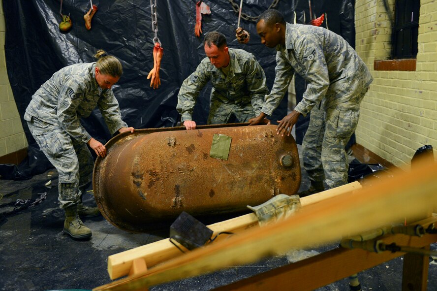 Staff Sgt. Evelyn Clemons, left, Tech Sgt. Ian Aeppli and Airman 1st Class Kevin Yator, 2nd Civil Engineer Squadron water and fuel systems maintenance craftsmen and apprentice, empty a bathtub at the old Security Forces Confinement Facility on Barksdale Air Force Base, La., Oct. 22, 2013. The bathtub will be used as a prop for the annual CE Haunted House. (U.S. Air Force photo Senior Airman Micaiah Anthony)
