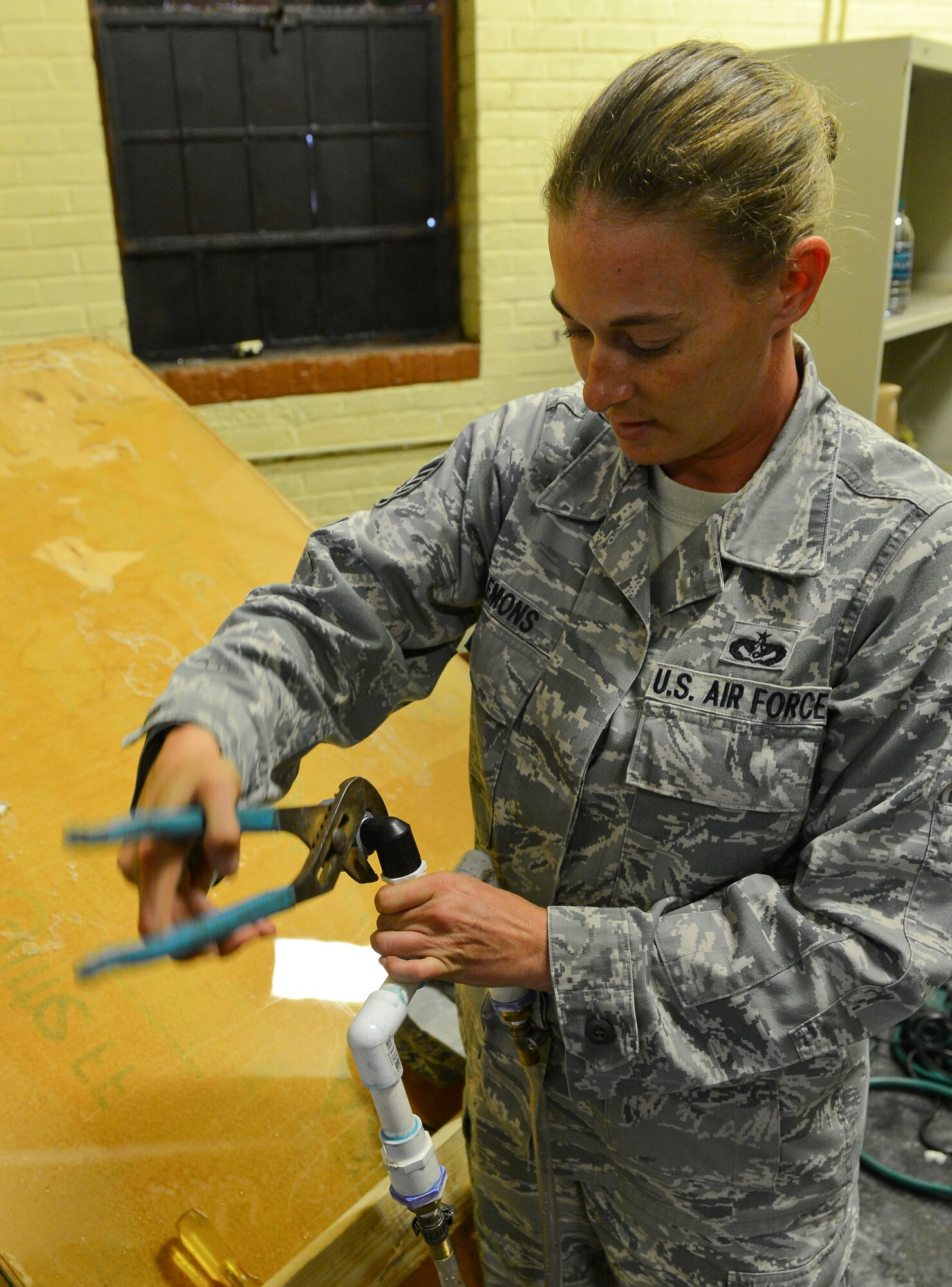 Staff Sgt. Evelyn Clemons, 2nd Civil Engineer Squadron water and fuel systems maintenance craftsman, works on a water pump at the old Security Forces Confinement Facility on Barksdale Air Force Base, La., Oct. 22, 2013. Clemons made modifications to a water pump so it could be used for a prop for the annual CE Haunted House.  (U.S. Air Force photo Senior Airman Micaiah Anthony)

