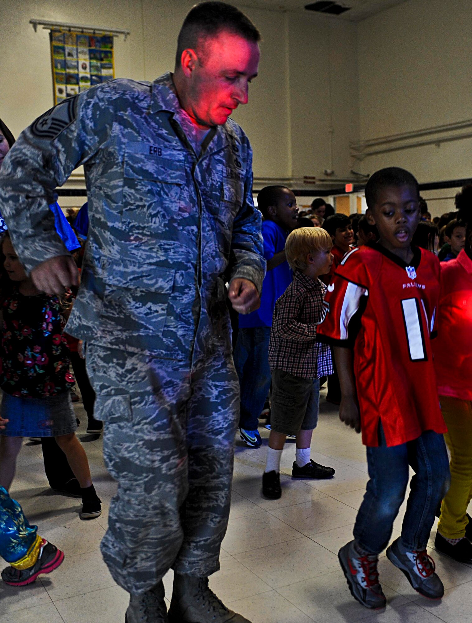 U.S. Air Force Senior Master Sgt. J.R. Erb, U.S. Air Force Heritage of America Band bassist, dances alongside students from Armstrong Elementary School after a performance by the band’s rock ensemble, “Full Spectrum,” in Hampton, Va., Oct. 18, 2013. The elementary school integrates visual arts, music, drama and dance into its curriculum, and used the ensemble’s performance as a teaching experience. (U.S. Air Force photo by Airman 1st Class R. Alex Durbin/Released)