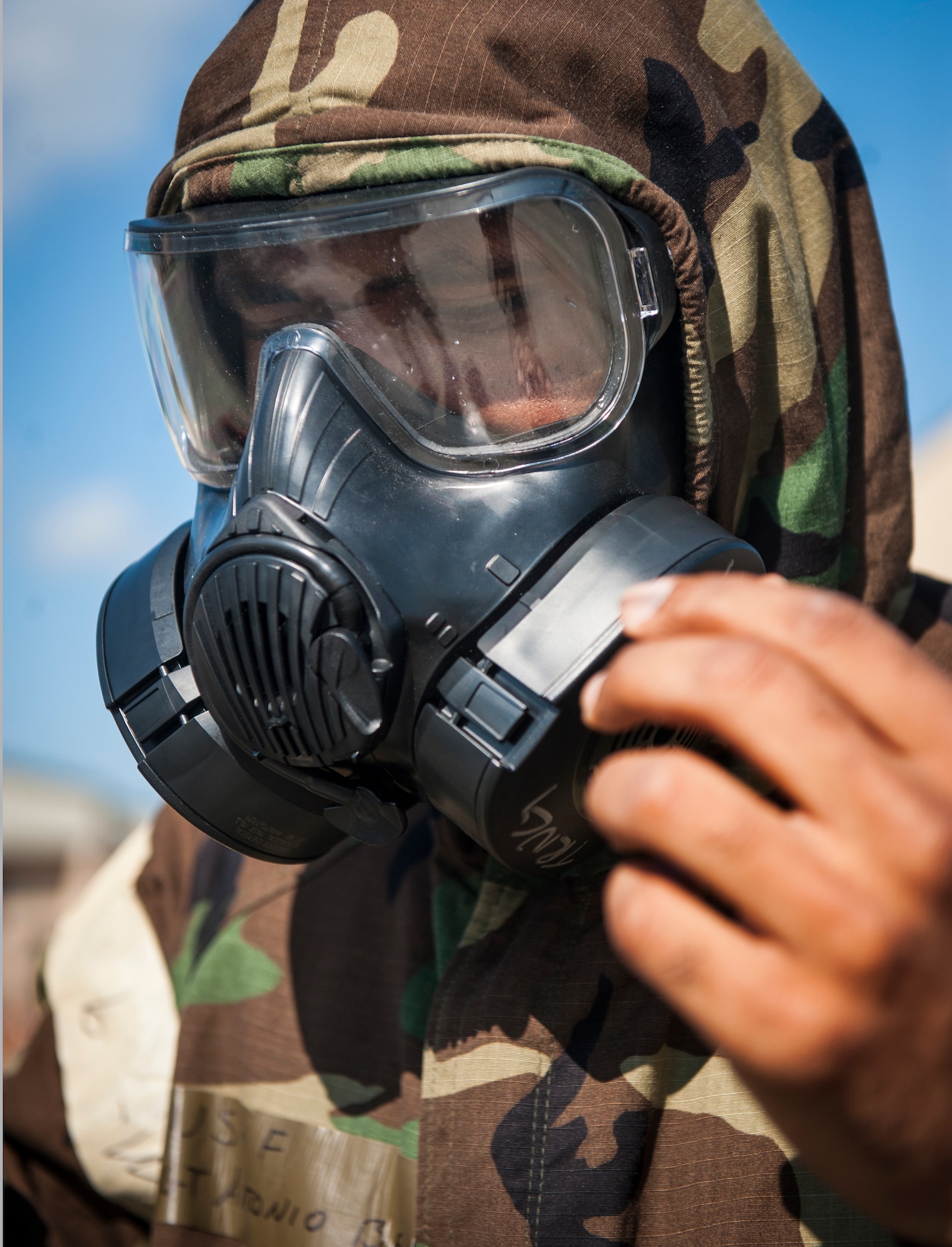 U.S. Air Force Master Sgt. Tony Bell, 347th Operations Support Squadron aircrew flight equipment (AFE) technician, finishes putting on a gas mask at Moody Air Force Base, Ga., Oct. 17, 2013. The AFE technicians put on mission-oriented protective posture (MOPP) gear to demonstrate the correct way to enter and exit an aircraft after a chemical attack without contaminating the inside. (U.S. Air Force photo by Senior Airman Jarrod Grammel/Released)
