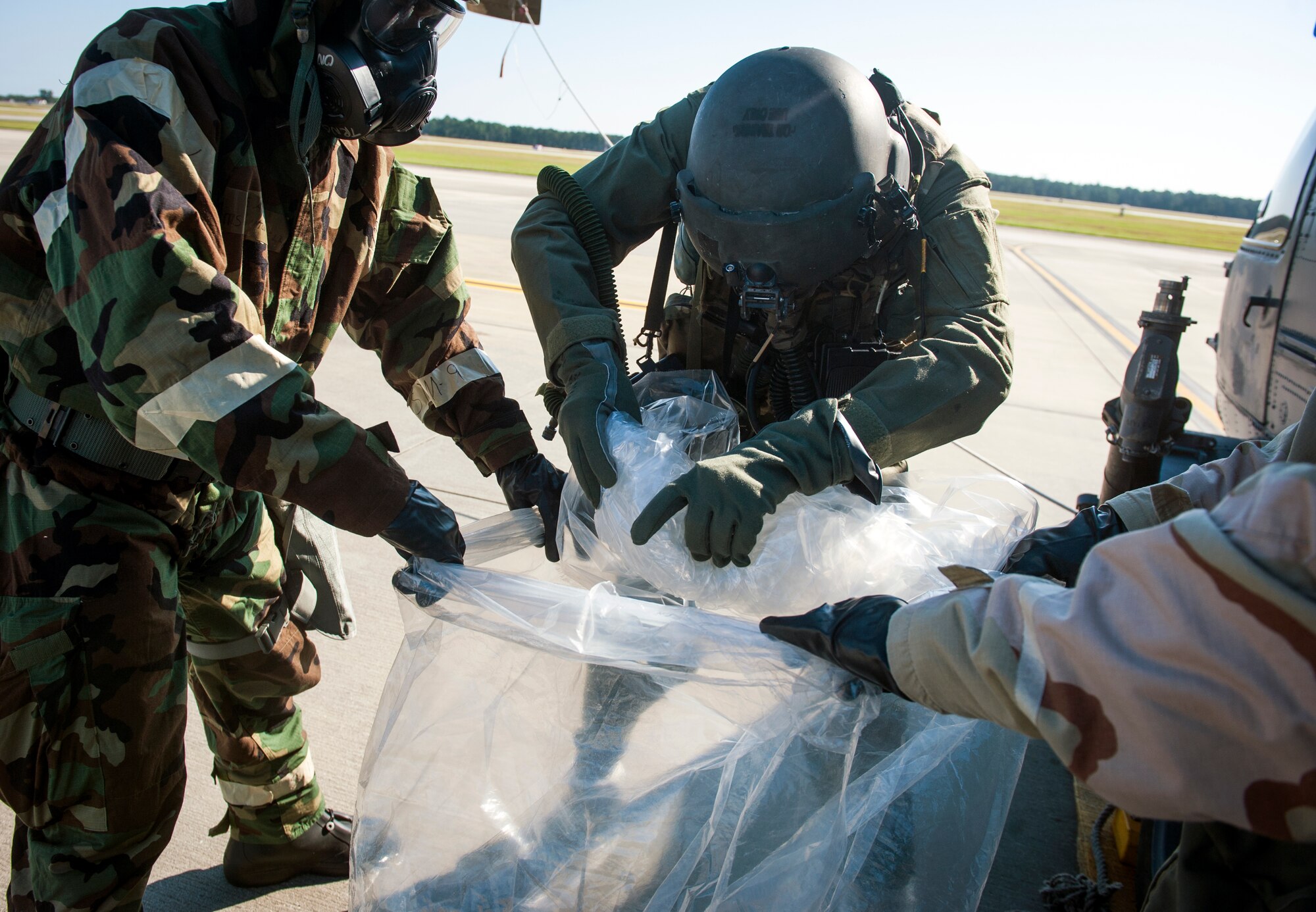 U.S. Air Force Airman 1st Class Michael Romero, 347th Operations Support Squadron aircrew flight equipment (AFE) technician, takes off an overcape at Moody Air Force Base, Ga., Oct. 17, 2013. Properly using overcapes and overboots ensure Airmen don’t get contaminants in the aircraft. (U.S. Air Force photo by Senior Airman Jarrod Grammel/Released)
