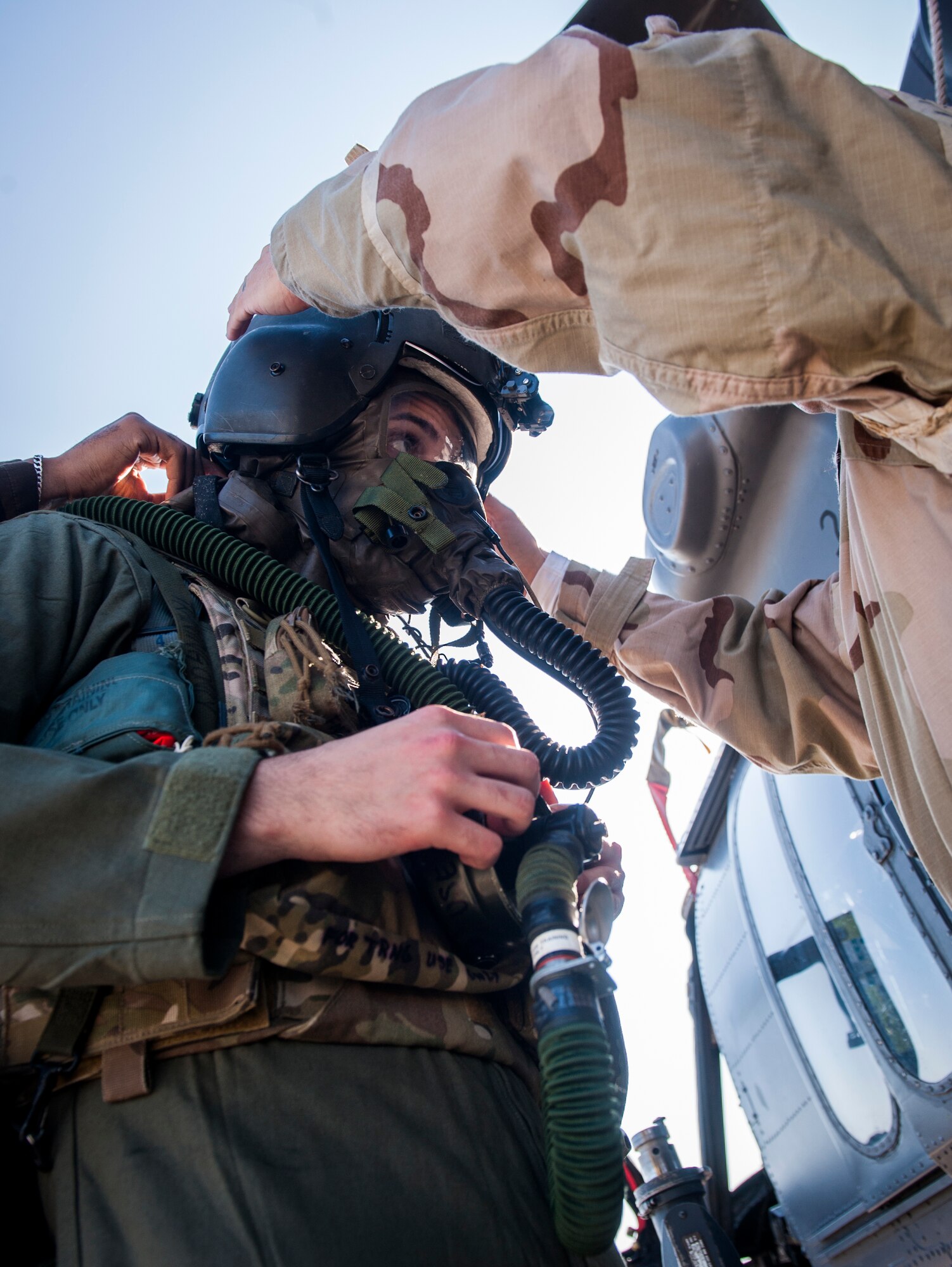 U.S. Air Force Airman 1st Class Michael Romero, 347th Operations Support Squadron aircrew flight equipment (AFE) technician, puts on a flight helmet with help from a wingman at Moody Air Force Base, Ga., Oct. 17, 2013. AFE technicians are responsible for inspecting, repairing and supplying equipment for aircrew members. (U.S. Air Force photo by Senior Airman Jarrod Grammel/Released)
