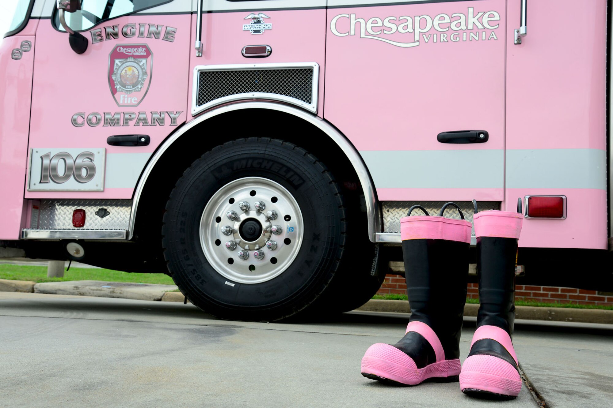 The 733rd Civil Engineer Division fire department donation boots are displayed beside the Chesapeake, Va. Fire Department fire truck, “Pinky,” at Fort Eustis, Va., Oct. 13, 2013. This is the second year the Fort Eustis firefighters have showcased “Pinky” around post to help raise funds for their breast cancer awareness month campaign. (U.S. Air Force photo by Staff Sgt. Ashley Hawkins/Released)