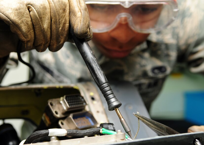 U.S. Air Force Senior Airman Darrius Gibbs, 4th Component Maintenance Squadron avionics technician, fixes an F-15E Strike Eagle navigation pod at Seymour Johnson Air Force Base, N.C., Oct. 17, 2013. Navigation pods help pilots see targets in terrains with low visibility and adverse weather conditions. (U.S. Air Force photo by Airman 1st Class John Nieves Camacho)