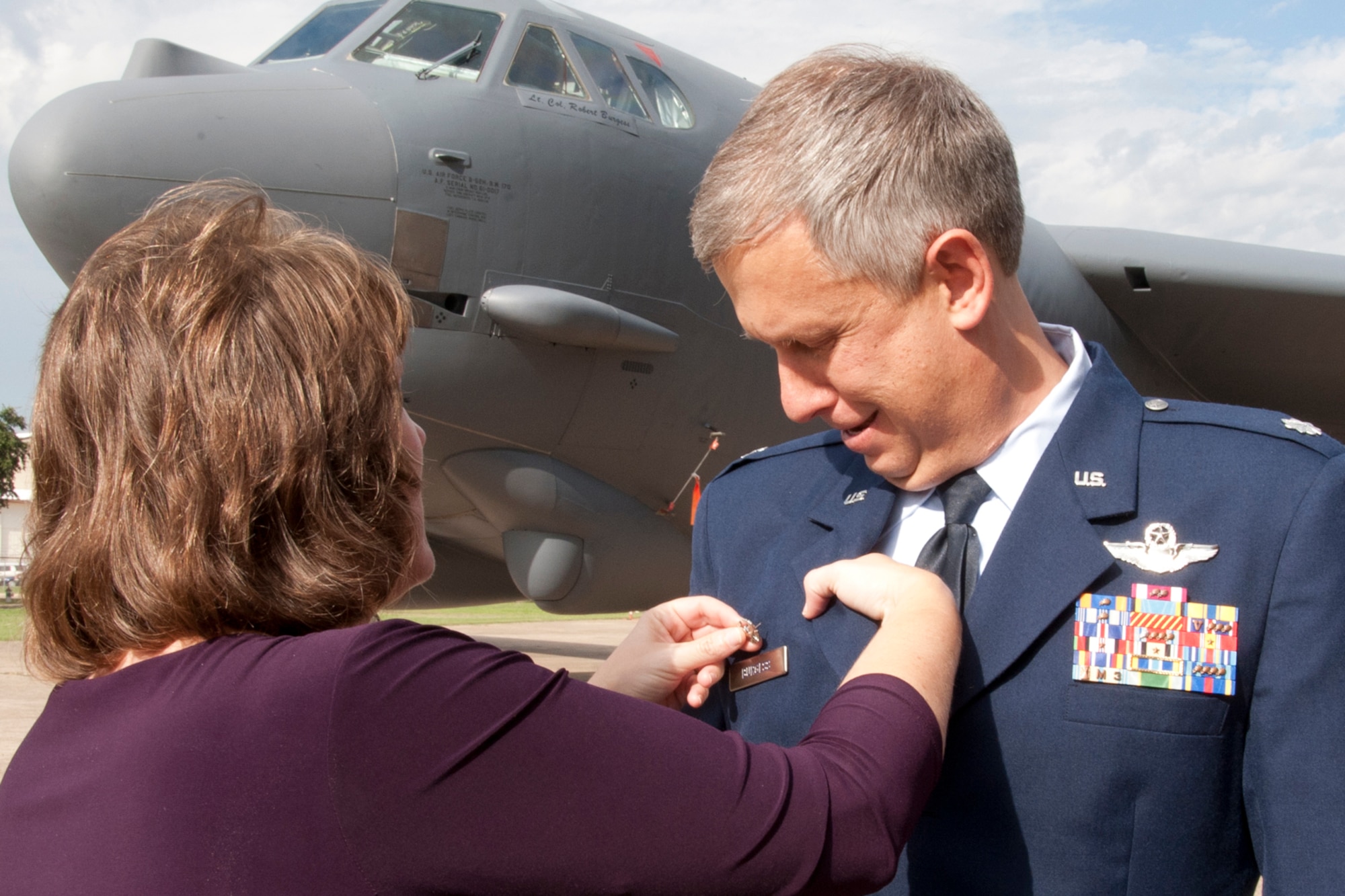 Martha Burgess, wife of Lt. Col.  Robert N. Burgess, commander, 343rd Bomb Squadron, pins on his command badge after a change of command ceremony at Barksdale Air Force Base, La., Oct. 21, 2013. Burgess took the reins of the 343 BS and became the third commander of the unit, which was officially reactivated at Barksdale on April 1, 2010. (U.S. Air Force photo by Master Sgt. Jeff Walston)