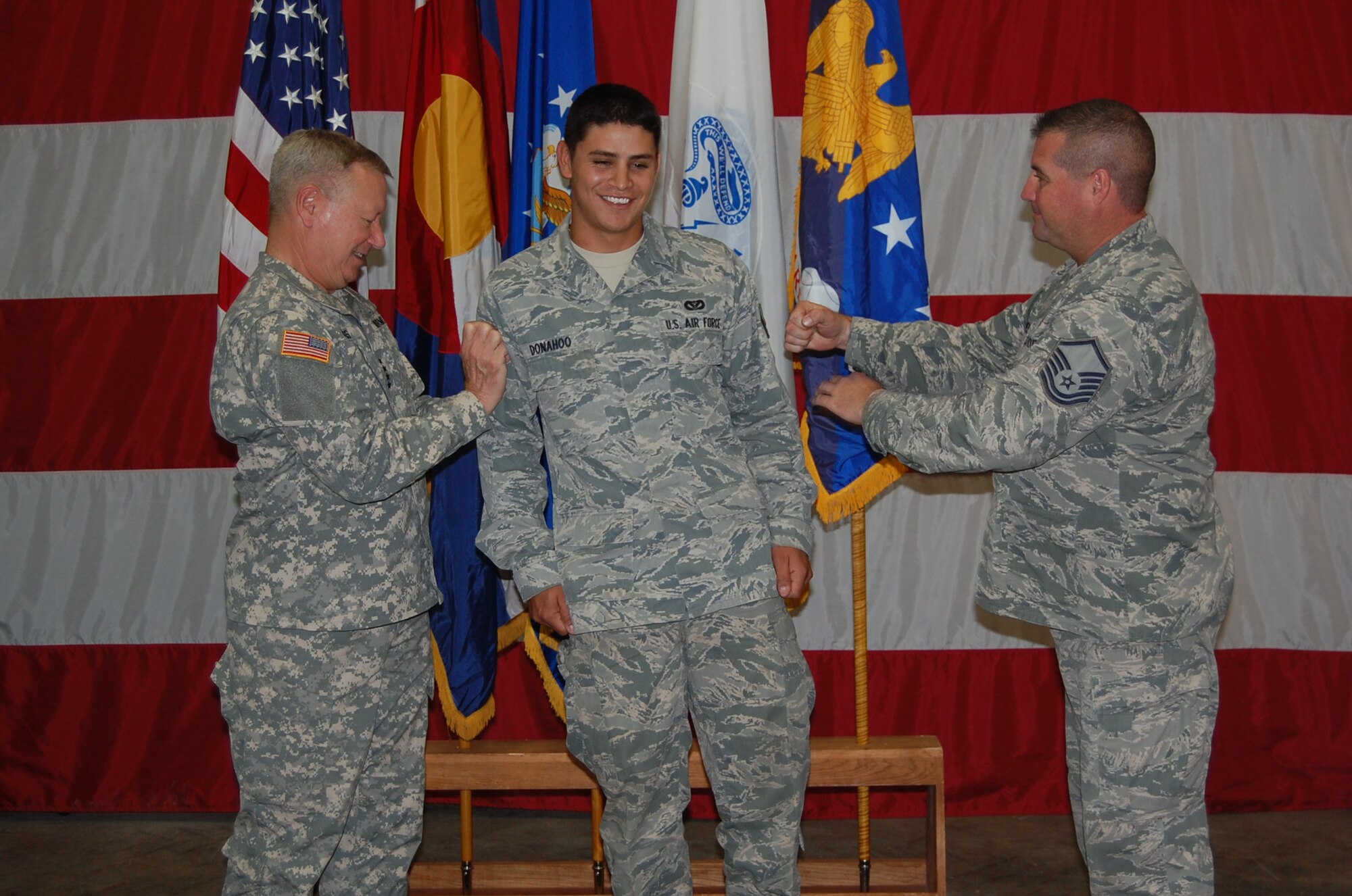 Gen. Frank Grass, chief, National Guard Bureau, spoke to the 233d Space Group during his visit and afterwards helped present awards and promote two individuals from the unit.  Airman Justin Donahoo, 233d Space Communications Squadron, earned another stripe to become a Senior Airman during the event. (Air National Guard photo by Capt. Kinder Blacke)
