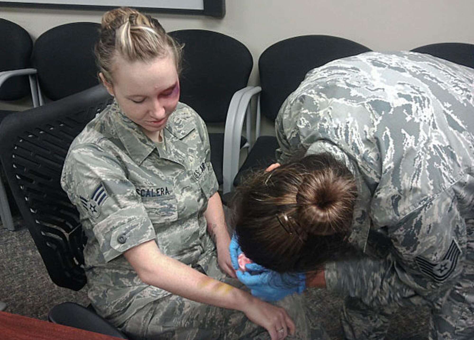 Tech. Sgt. Rebecca Estes, 1st Special Operations Medical Group Family Health flight chief, applies make-up to Senior Airman Skye Escalera, 1st SOMDG health benefits advisor, at Hurlburt Field, Oct. 9, 2013. Bruises were placed on Escalera's eye and arm during the recent Black Eye Campaign to raise awareness for domestic violence.