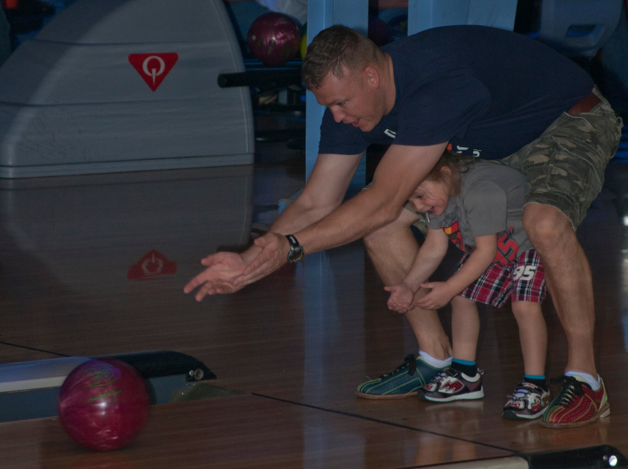 131017-F-GZ967-028 Master Sgt. Kevin Akers, Maintenance Operations Squadron first sergeant, helps his daughter Kaylissa, 3, roll a bowling ball down the lanes during the “Strike Out Domestic Violence” bowling tournament at the Warren Lanes Oct. 17, 2013. Akers and his daughter bowled with a group of first sergeants in the tournament. (U.S. Air Force photo by Airman 1st Class Brandon Valle)