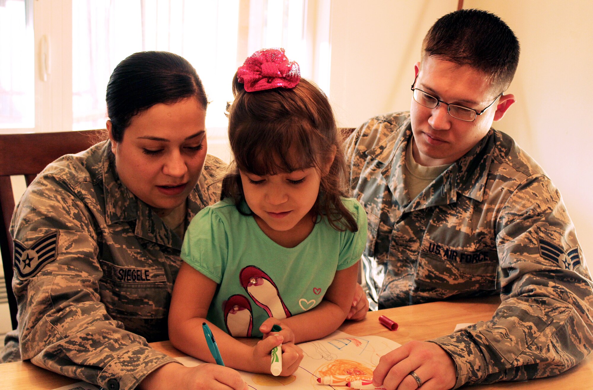 Air Force Staff Sgt. Sabrina Siegele and her husband, Air Force Senior Airman Matt Siegele, enjoy time after work with their daughter, Stephanie, at Joint Base Lewis-McChord, Wash. The Siegeles say they like the age-appropriate scenarios of the new MilitaryParenting.org website. (DOD photo) 