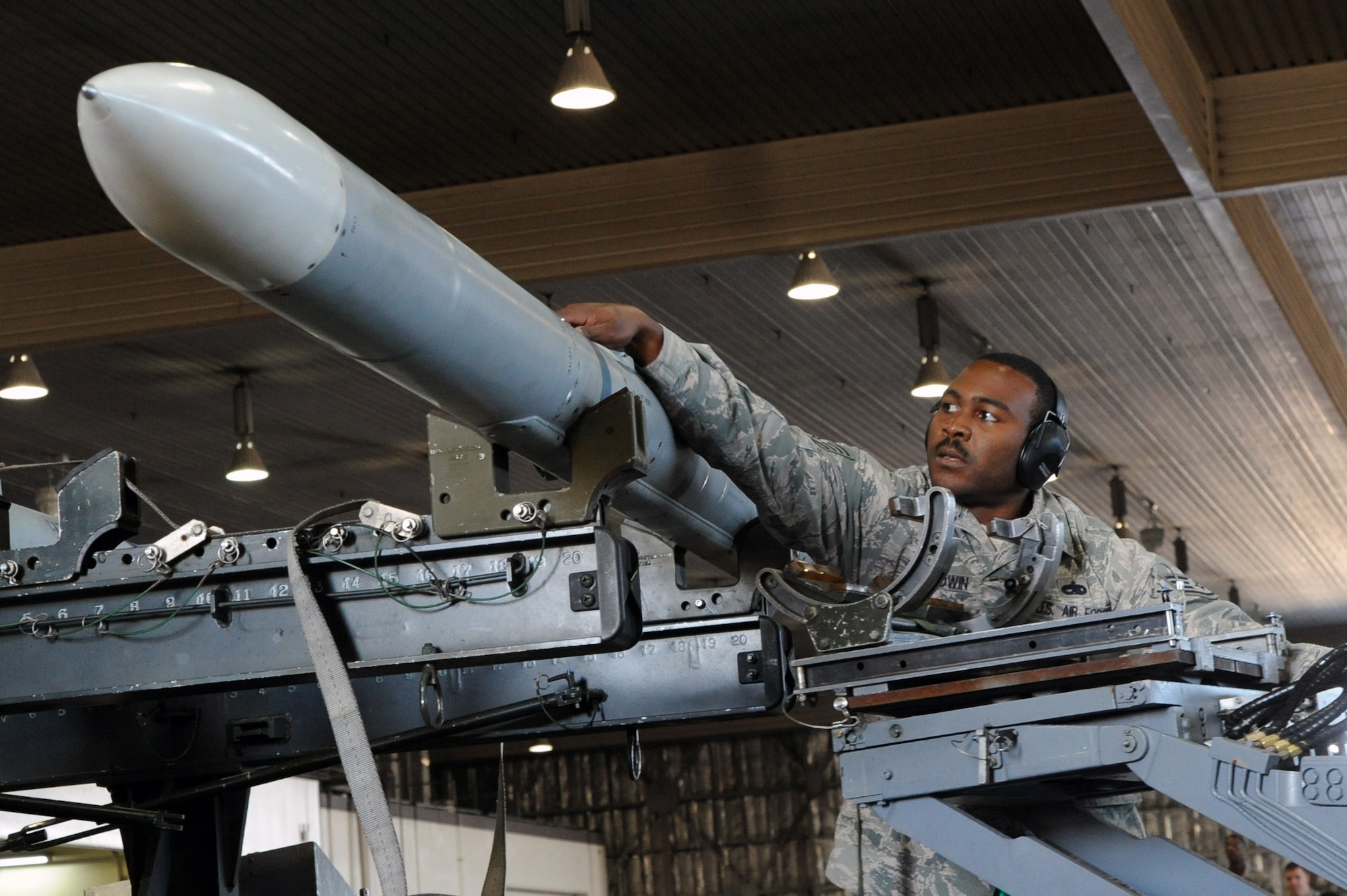 U.S. Air Force Staff Sgt. Ryan Baldwin, 13th Aircraft Maintenance Unit weapons load team chief, unloads an AIM-120 Advanced Medium-Range Air-to-air Missile to be put on an F-16 Fighting Falcon during the Load Crew of the Quarter competition at Misawa Air Base, Japan, Oct. 18, 2013. The three-man crew teams loaded an AGM-88 High-speed Anti-radiation Missile, an AIM-120 AMRAAM, and an AIM-9 Sidewinder, a short-range air-to-air missile. (U. S. Air Force photo by Senior Airman Derek VanHorn)