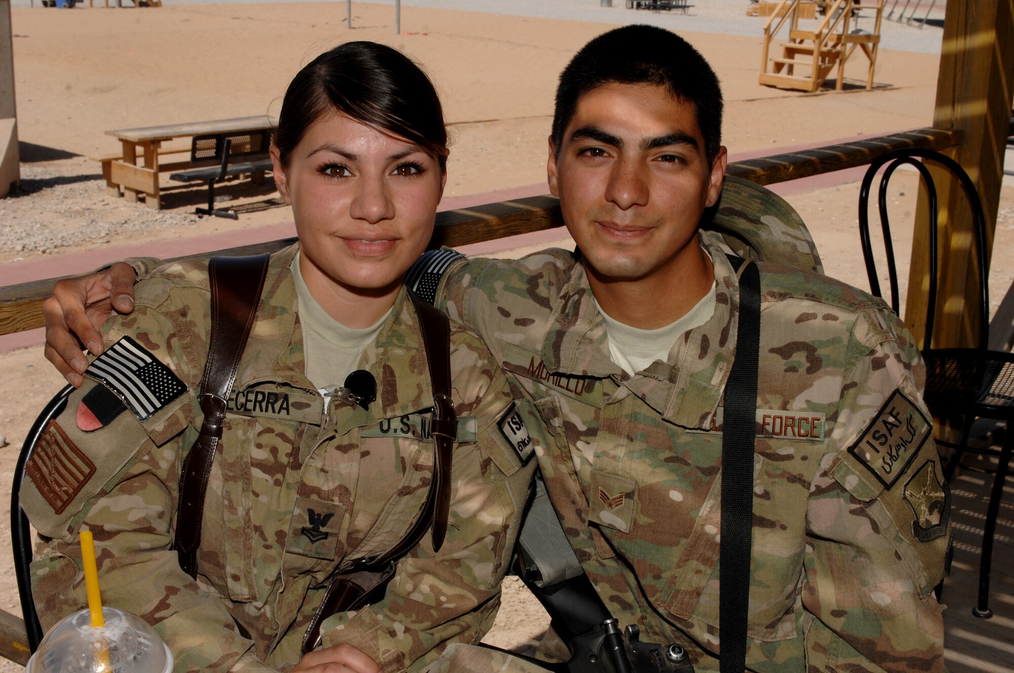 Petty Officer 2nd Class Alexandra Becerra and her brother Senior Airman Andrew Murillo sit on the boardwalk at Kandahar Airfield, Afghanistan, spending their down time together Sept. 7, 2013. Becerra works medical logistics at the Role 3 Medical Clinic, and Murillo is an aerial porter for the 451st Air Expeditionary Wing. Both are deployed to KAF. (U.S. Air Force photo by Senior Airman Jack Sanders)