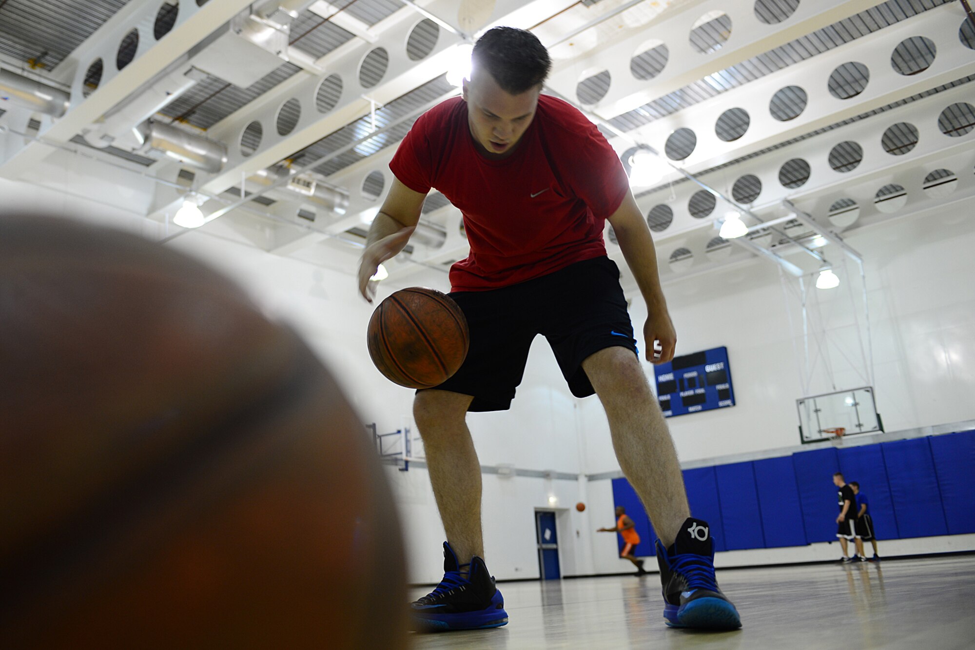 Senior Airman Kelley Parker, 48th Medical Operations Squadron mental health technician, warms up before a pick-up game of basketball at the Royal Air Force Lakenheath, England, Fitness Center, Sept. 12, 2013. Sports allow Liberty Airmen to come together, promote fitness and build teamwork outside of the duty day. (U.S. Air Force photo by Airman 1st Class Dana J. Butler/Released)