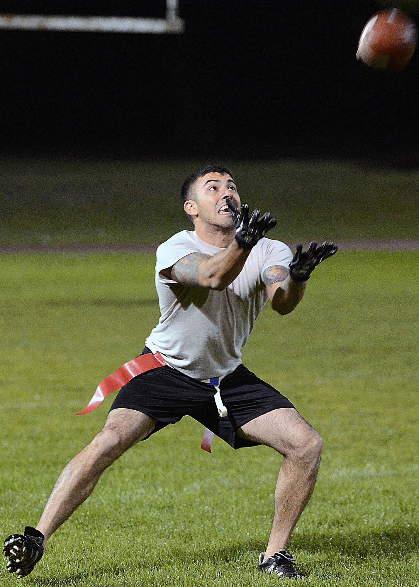 A 48th Security Forces Squadron member catches a football during an intramural flag football game at Royal Air Force Lakenheath, England, Sept. 10, 2013. Intramural sports are a way for Liberty Airmen to come together and promote fitness and build teamwork outside of the duty day. (U.S. Air Force photo by Airman 1st Class Trevor T. McBride/Released) 
