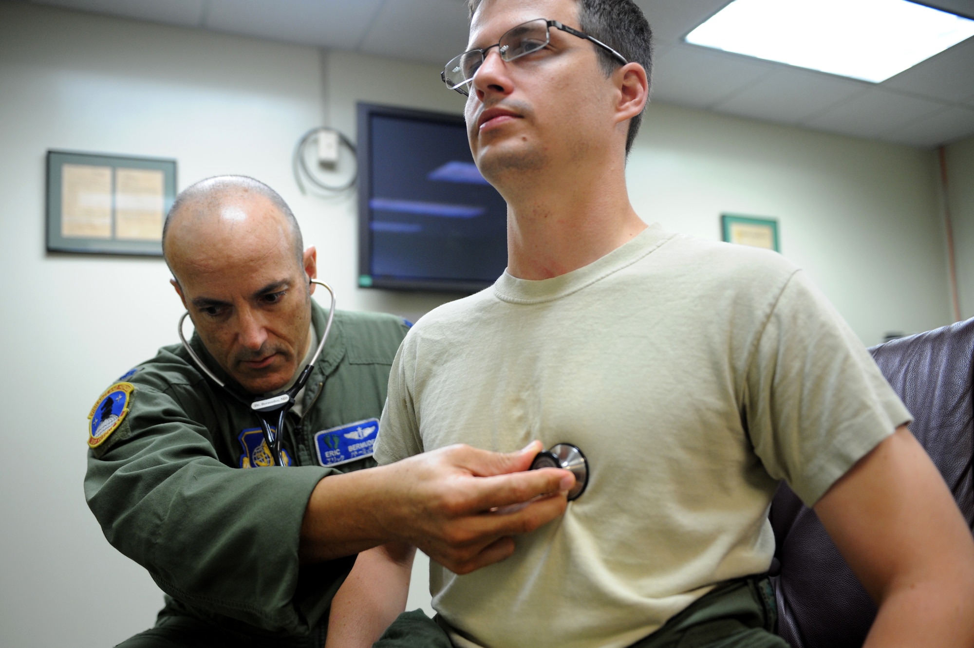 U.S. Air Force Lt. Col. James Bermudez, 31st Rescue Squadron flight surgeon, listens to the heart of Capt. Andrew Alderman, 33rd Rescue Squadron pilot, during a squadron visit on Kadena Air Base, Japan, Oct. 21, 2013. Bermudez visits flying squadrons on a weekly basis, depending on his schedule within the flight medicine clinic, in order to get to know the aircrew and speak with them about medical concerns when they arise. (U.S. Air Force photo by Airman 1st Class Hailey R. Davis)