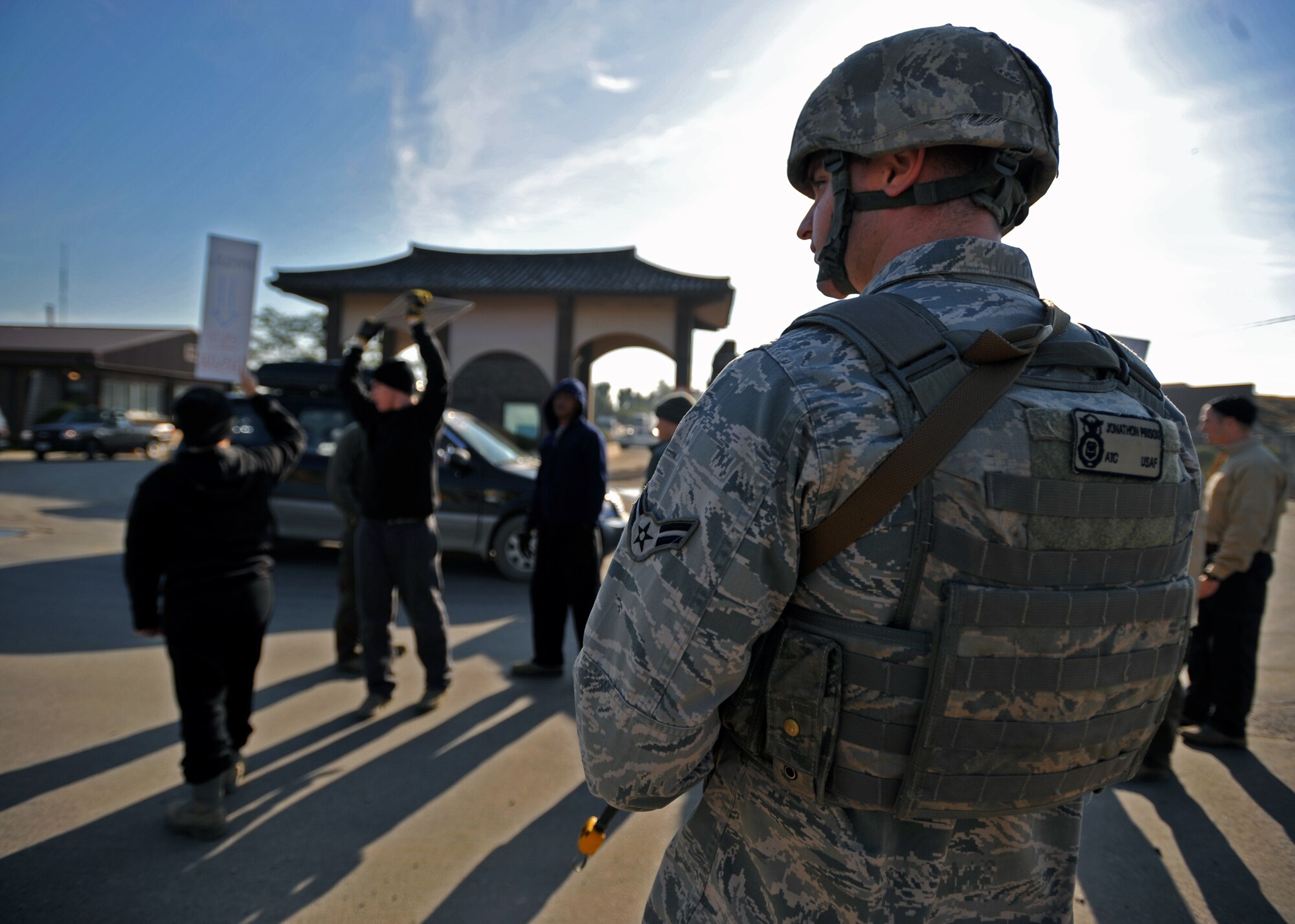 Airman 1st Class Jonathon Pinson, 51st Security Forces Squadron fire team member, stands guard during a protest scenario at Osan Air Base, Republic of Korea, Oct. 17, 2013. The protestors in this scenario were later utilized as opposition forces role players that attempted to infiltrate the base and attack the Osan flight line. (U.S. Air Force photo/Senior Airman Siuta B. Ika)