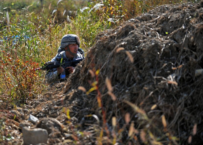 Senior Airman Hong Dick Li, 51st Security Forces Squadron fire team member, takes cover during a field training exercise near the perimeter of Osan Air Base, Republic of Korea, Oct. 18, 2013. Li and his fire team were dispatched after receiving intelligence that opposition forces were planning to infiltrate the base. (U.S. Air Force photo/Senior Airman Siuta B. Ika)