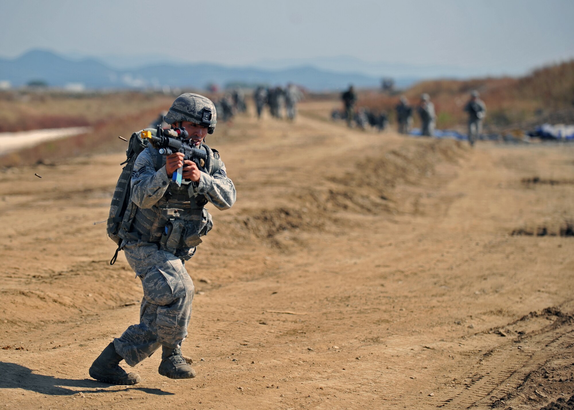 Senior Airman Hong Dick Li, 51st Security Forces Squadron fire team member, shoots at opposition forces members during a field training exercise near the perimeter of Osan Air Base, Republic of Korea, Oct. 18, 2013. Li was the “point man” during the team’s trek back to the convoy after a simulated improvised explosive device disabled one of the team’s tactical vehicles. (U.S. Air Force photo/Senior Airman Siuta B. Ika)