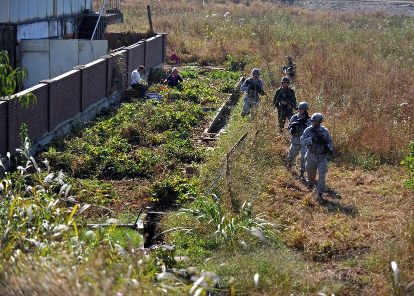 First responders led by Staff Sgt. Darryl Thompson, 51st Security Forces Squadron fire team leader, conduct a perimeter sweep during a field training exercise near the perimeter of Osan Air Base, Republic of Korea, Oct. 18, 2013. This part of the exercise allowed 51st SFS fire team members to practice multiple battlefield and defense tactics that culminated in neutralizing opposition forces role players who were attempting to infiltrate the base. (U.S. Air Force photo/Senior Airman Siuta B. Ika)