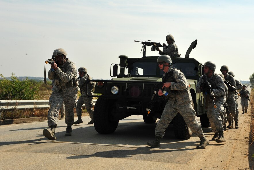 Members of the 51st Security Forces Squadron rush from a tactical vehicle during a field training exercise at Osan Air Base, Republic of Korea, Oct. 17, 2013. Airmen fired blank rounds while engaging “enemy” forces in a simulated ambush. (U.S. Air Force photo/Airman 1st Class Ashley J. Thum)