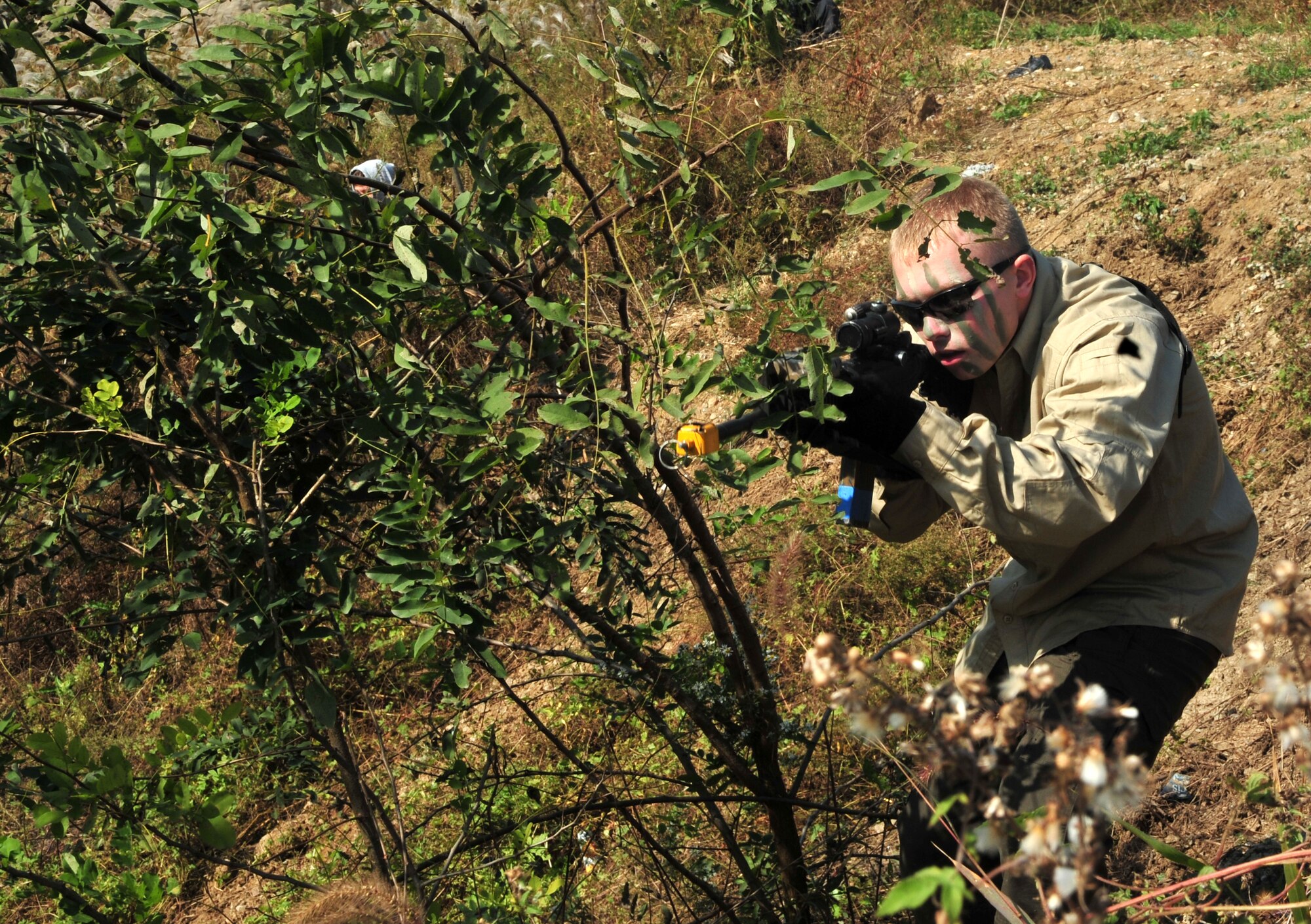 Airman 1st Class Brian Loughmiller, 51st Security Forces Squadron entry controller, waits in a concealed position during a field training exercise at Osan Air Base, Republic of Korea, Oct. 17, 2013. Several Airmen used the landscape to disguise themselves while waiting for “enemy” forces to approach. (U.S. Air Force photo/Airman 1st Class Ashley J. Thum)