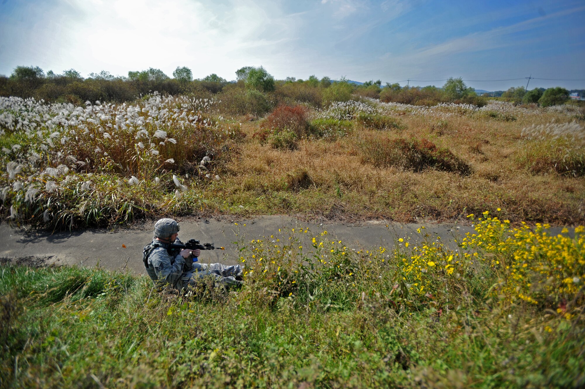 Staff Sgt. Adam Dodge, 51st Security Forces Squadron fire team leader, waits for backup after being wounded during a field training exercise near the perimeter of Osan Air Base, Republic of Korea, Oct. 17, 2013. During this particular scenario, 51st SFS fire teams responded to a mortar threat and were met and engaged by members of the 51st SFS role playing as opposition forces members. (U.S. Air Force photo/Senior Airman Siuta B. Ika)